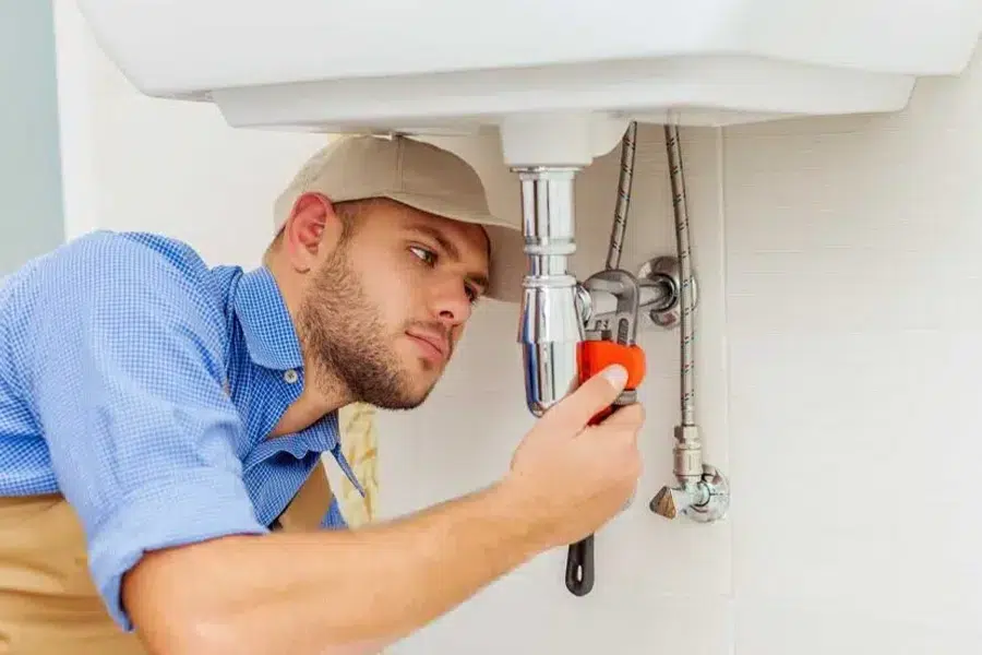 Professional plumber repairing pipes