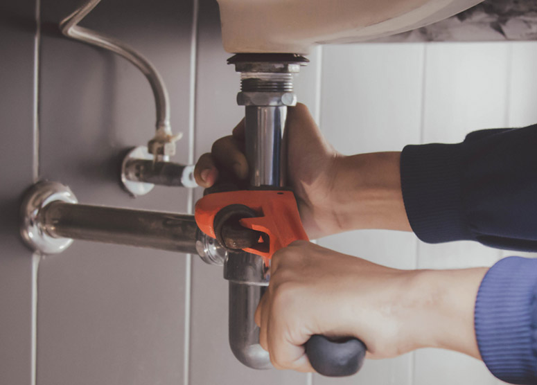 Plumber repairing sink pipes in Irving Texas
